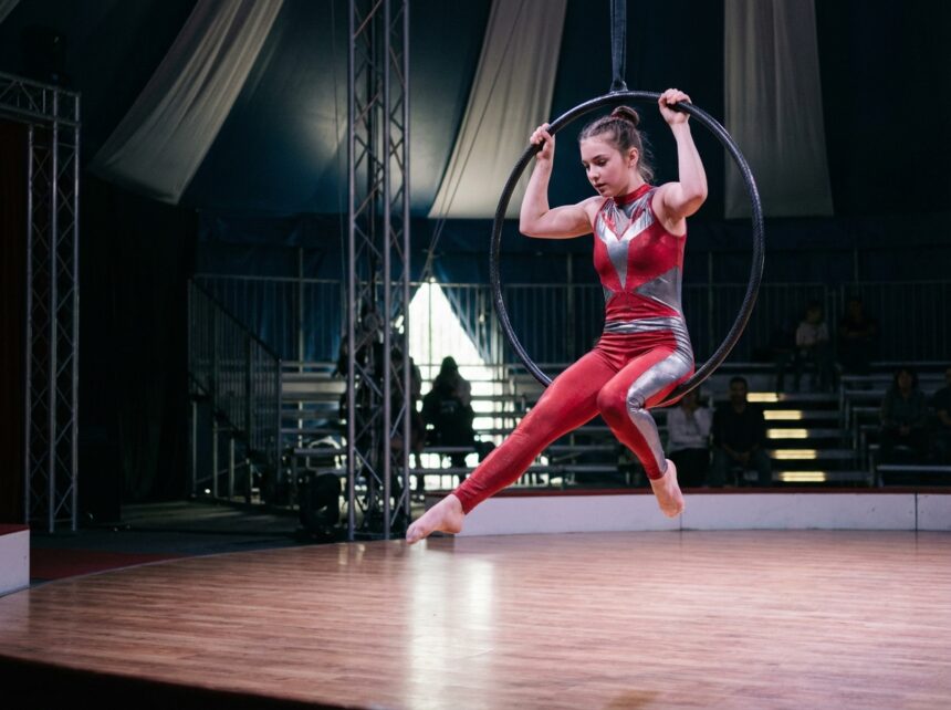 Acrobate en costume rouge et argent lors d'un spectacle de cirque moderne