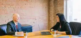 man and woman talking inside office