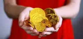 person holding gold-colored ching coins